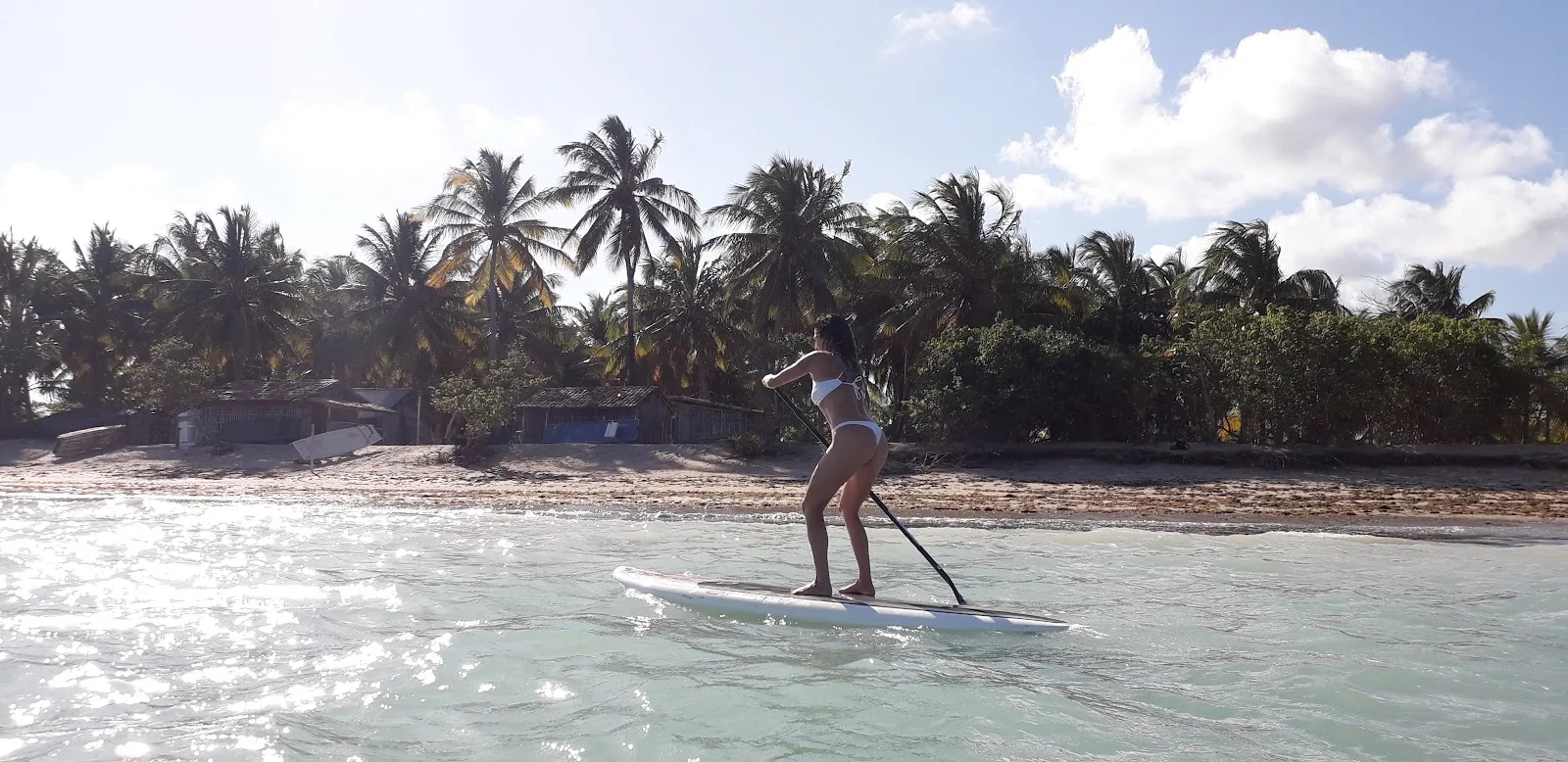 Pessoa remando em pé numa prancha de stand-up paddle no mar de Tatuamunha